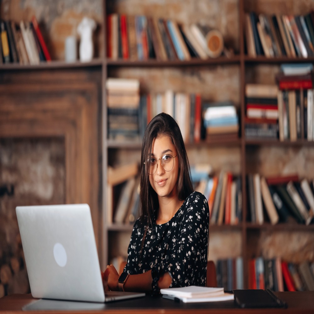 young-woman-glasses-works-laptop-while-sitting-table