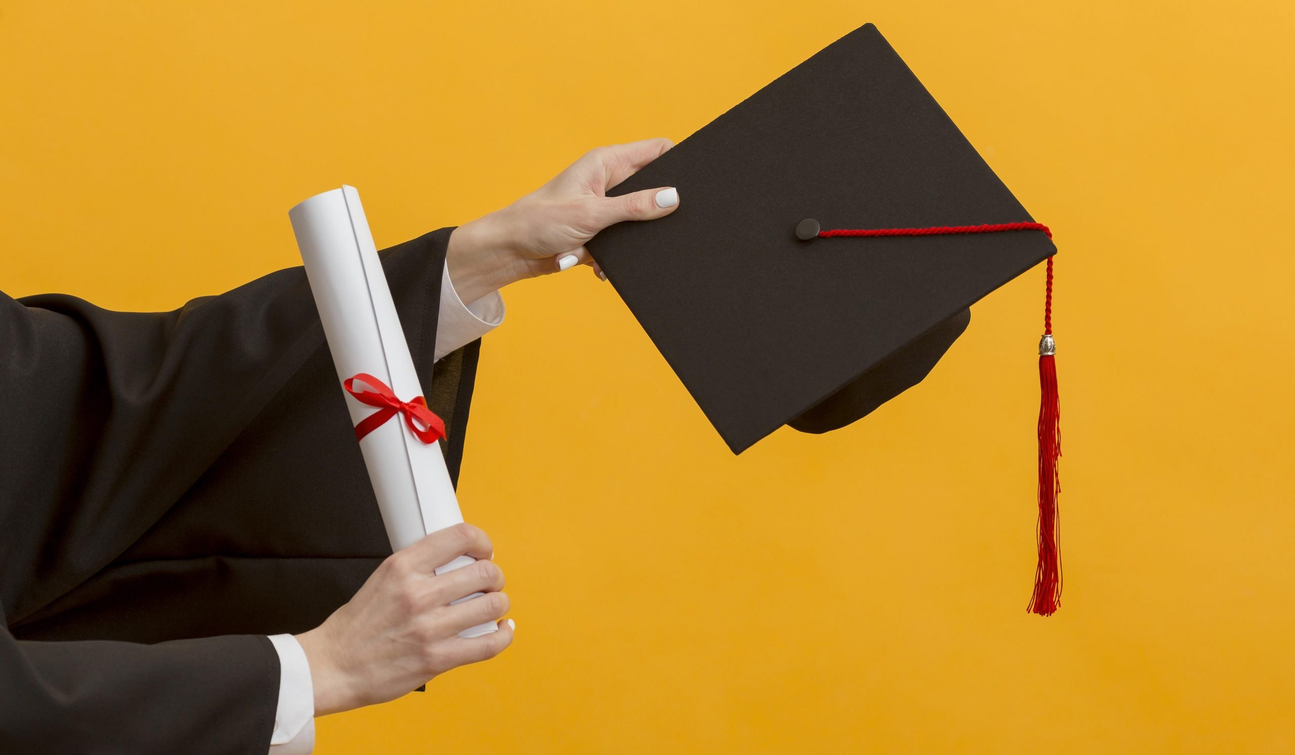 close-up-hands-holding-diploma-cap-scaled